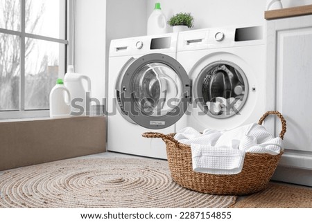 Modern washing machines with dirty clothes in laundry room Royalty-Free Stock Photo #2287154855