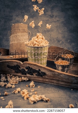 Popcorn in a paper cup on a blue background. Toned.