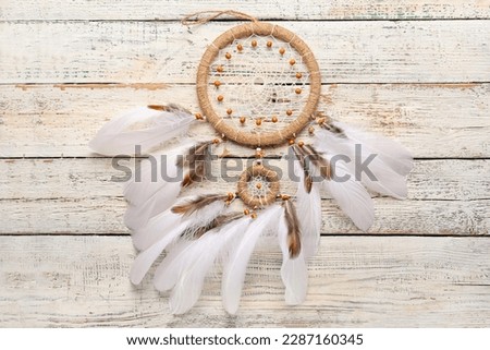 Dream catcher on white wooden background