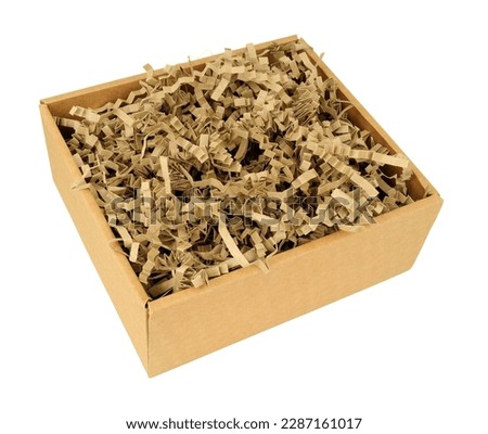 Cardboard box filled with zig zag shredded paper strips packing material Royalty-Free Stock Photo #2287161017