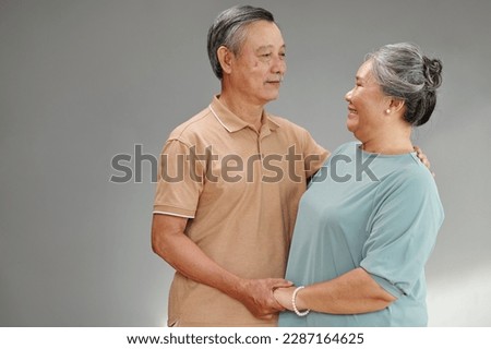 Studio portrait of senior couple dancing and looking at each other