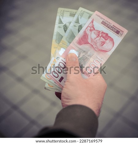 Mans hand holding serbian dinars Royalty-Free Stock Photo #2287169579