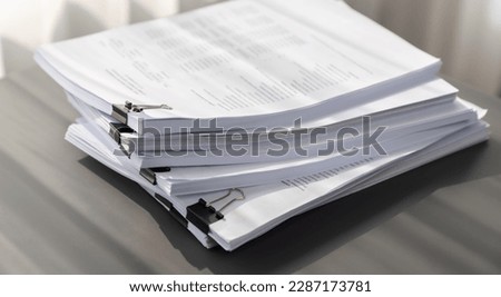 Closeup office table with organized stacked papers, as the concept of organized document management system for busy business reports or legal papers. equility