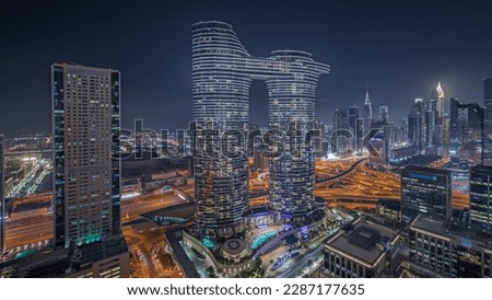 Panorama showing futuristic Dubai Downtown and finansial district skyline aerial night . Many illuminated towers and skyscrapers with traffic on streets