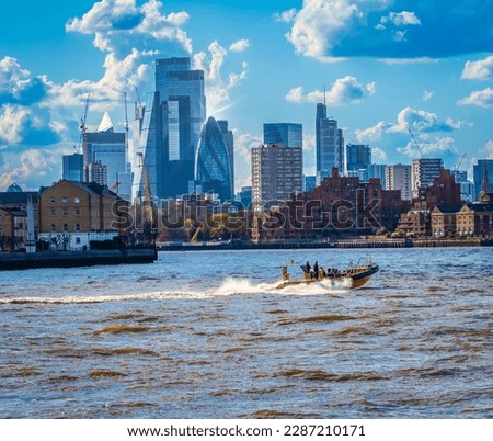 A speed boat on the Thames with central London buildings in the background  Royalty-Free Stock Photo #2287210171