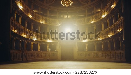 Wide shot of an Empty Elegant Classic Theatre with Spotlight Shot from the Stage. Well-lit Opera House with Beautiful Golden Decoration Ready to Recieve Audience for a Play or Ballet Show Royalty-Free Stock Photo #2287233279