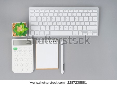 Workspace desk with open blank notebook and calculator with computer keyboard for creative flat lay concept