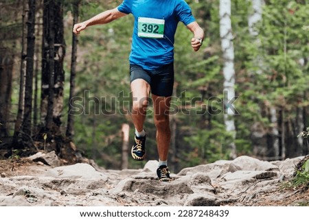male runner athlete running stones trail marathon race in forest, sports photos