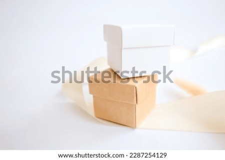 Small craft boxes for packing jewelry on a white holiday background. The concept of packaging, holiday, gifts. Place for text and logo. High quality photo