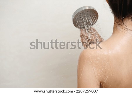 woman taking shower and washing hair with shampoo Royalty-Free Stock Photo #2287259007