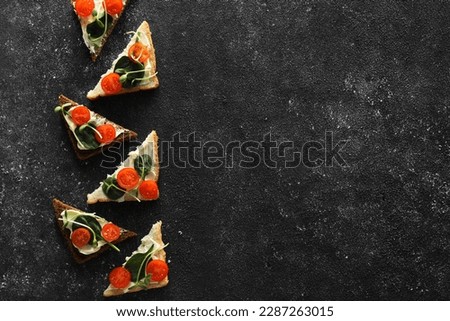 Food photography. Tasty sandwiches with cream cheese, tomato, basil and microgreen on grey textured table, flat lay with space for text