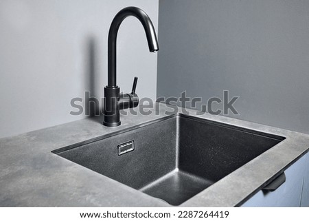 Single handle water filter kitchen faucet for reverse osmosis or water filtration system built in compact high pressure laminate HPL countertop. Kitchen undermount installation granite composite sink. Royalty-Free Stock Photo #2287264419
