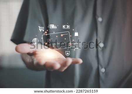 Hand holding credit card and using laptop. Businessman or entrepreneur working from home. Online shopping, e-commerce, internet banking, spending money, work from home concept.
