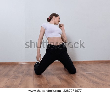 A girl in a white T-shirt performs her dance