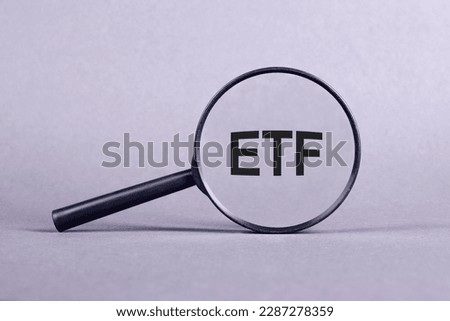ETF analysis concept. Word through magnifying glass. High quality photo