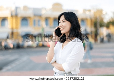 Portrait beautiful young asian woman with smart mobile phone around outdoor street view in a summer day Royalty-Free Stock Photo #2287282129