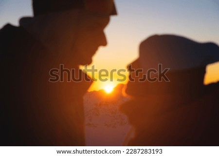 Couple portrait, silhouette of lovers looking at each other and smiling, against the backdrop of the setting sun
