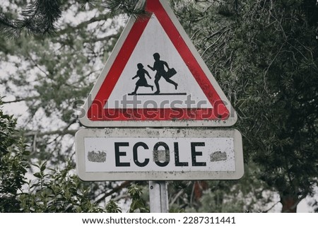 a sign or information on the side of the road with the image of an ecole.