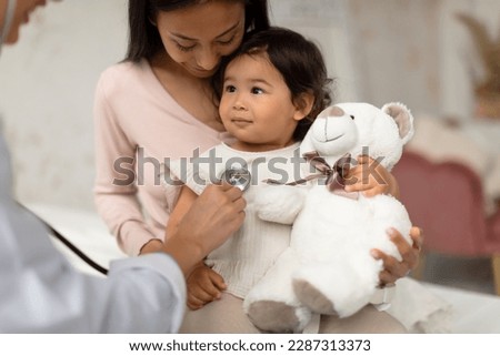 Baby Health Check Up. Korean Mom And Infant Daughter Having Medical Appointment, Unrecognizable Doctor Listening To Little Girl's Heart Putting Stethoscope To Her Chest In Modern Clinic Indoors Royalty-Free Stock Photo #2287313373