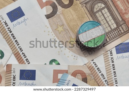 euro coin with national colorful flag of uzbekistan on the euro money banknotes background