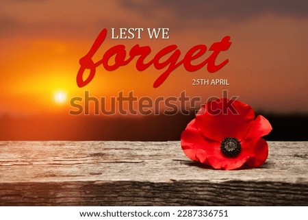 Poppy pin for Anzac Day. Poppy flower on old beautiful high grain, detailed wood on background of sunset sky. Lest We Forget.