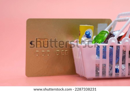 Food and groceries in shopping basket with credit card on pink background. copy space. shopping online,paying concept. space for text