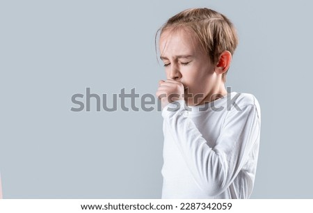 Boy coughing sick colds sneezing cough. Child got sick with a virus. Children coughs. Child is ill, he coughs. Treatment of colds and flu. Covid-19. Royalty-Free Stock Photo #2287342059
