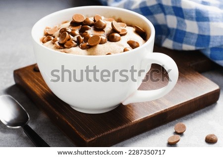 Peanut Butter and Chocolate Chips Mug Cake, Homemade Cake Cooked in the Microwave on Bright Background Royalty-Free Stock Photo #2287350717