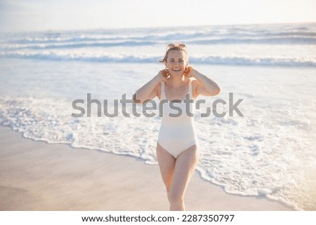 happy elegant female in white beachwear at the beach relaxing.
