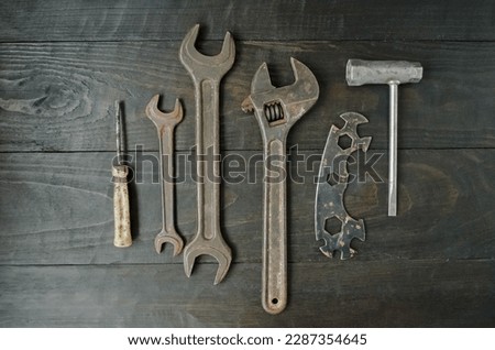 On a wooden background, carpentry and hand tools for work, wrenches, an old screwdriver and a pipe wrench.  Flat lay top view, close-up.  The concept of men's work.