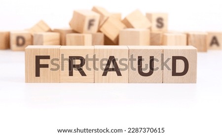 text FRAUD made of wooden cubes and different words on white background.