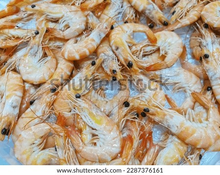 Detailed view of several whole fresh prawns surrounded by crushed ice for sale at a supermarket fishmonger, commercial food photography... Royalty-Free Stock Photo #2287376161