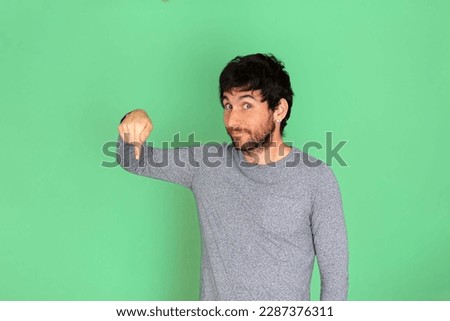 Young caucasian man pointing a finger towards one direction. Green screen background. Technologies concept. Humor. Business. Networking concept. Social networks.