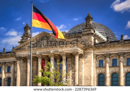 The Reichstag building in Berlin City. Flag of the Federal Republic of Germany is waving in front of the national german parliament. Royalty-Free Stock Photo #2287396369