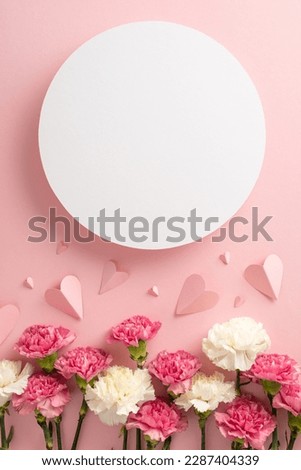 Mother's Day gift idea. Top view vertical flat lay of pretty pink present boxes, adorned with carnation flowers and pink paper hearts, on a soft pastel pink background