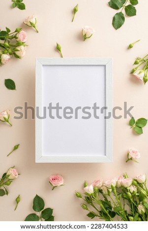 Simple beauty of small roses on a calming pastel beige background makes top vertical view flat lay an ideal backdrop for advertising or branding, with a blank frame