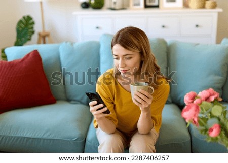 Woman using smartphone and drinking coffee in the morning