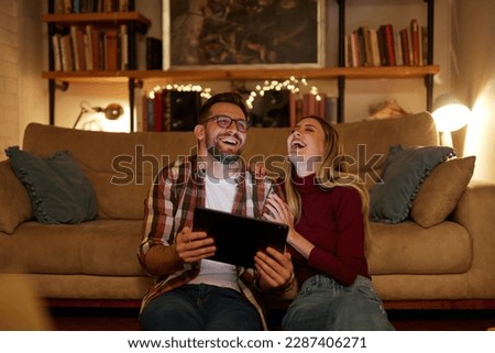 Young couple spending evening at home using digital tablet
