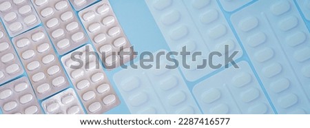 Pharmaceutical medication and medicine pills in packs on blue background. White pills in blister packs. Healthcare and medicine concept