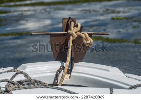 anchor tied with a rope to the bow of the speedboat