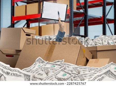 Hand among boxes and money. Warehouse revision. Audit of commodity balances. Metaphor of financial problems. Clipboard in hand of storekeeper. Revision in storage. Warehouse industry