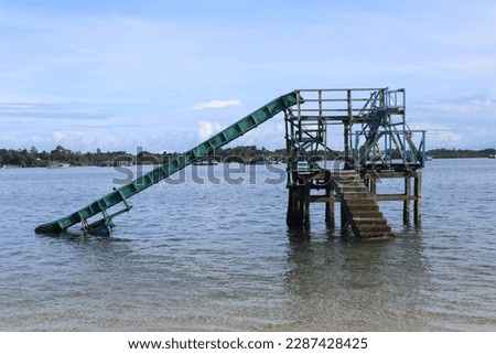Aru Islands-Indonesia, 11 April 2023 A slide game on the beach with green paint made of iron with a combination of stairs made of concrete. Royalty-Free Stock Photo #2287428425