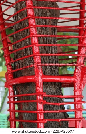 Aru Archipelago-Indonesia, April 11 2023 A tree covered with a red iron shield to beautify the appearance of a garden Royalty-Free Stock Photo #2287428697