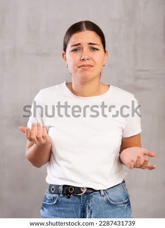 Upset young woman in casual clothes posing indoors