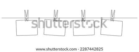 Photo frames hanging on the rope with clothespins in one continuous line drawing. Clothesline with pin and peg for photo album design concept in simple linear style. Editable stroke. Doodle vector