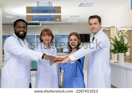 Diversity group of successful doctors showing unity with their hands together, Image of professional doctors show cheer up hands sign as symbol of their partnership. Teamwork agreement success concept Royalty-Free Stock Photo #2287451013
