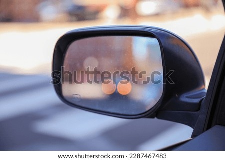 Car mirror in a stock photo symbolizes reflection, perspective, and awareness. It represents the importance of looking back, being mindful of surroundings, and gaining insights from past experiences  Royalty-Free Stock Photo #2287467483