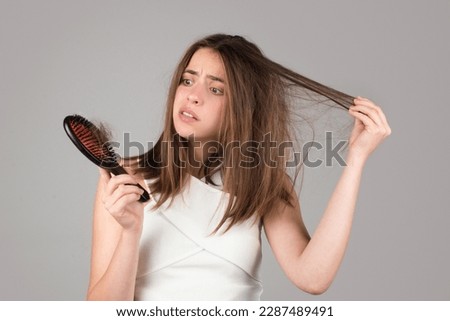 Woman hand holding comb with serious hair loss problem for health care shampoo. Royalty-Free Stock Photo #2287489491