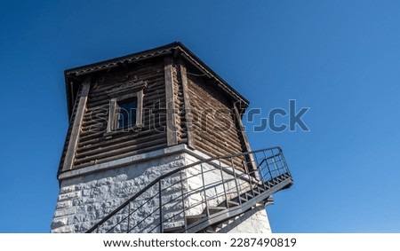 A tower with a spiral staircase against the sky.