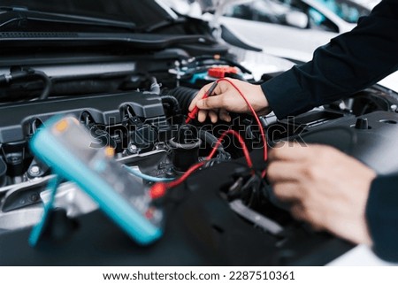 Technician Hands of car mechanic working repair in auto repair Service electric battery and Maintenance of car battery. Check the electrical system inside the car. Royalty-Free Stock Photo #2287510361